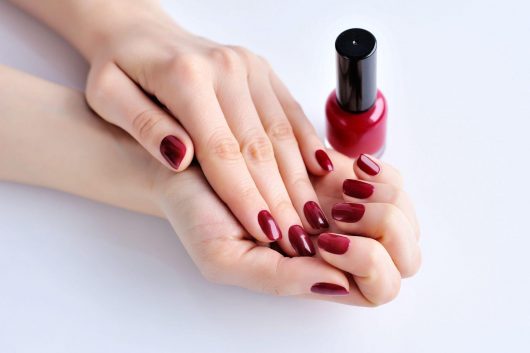 hands-of-a-woman-with-dark-red-manicure-and-nail-P5VNS4S.jpg